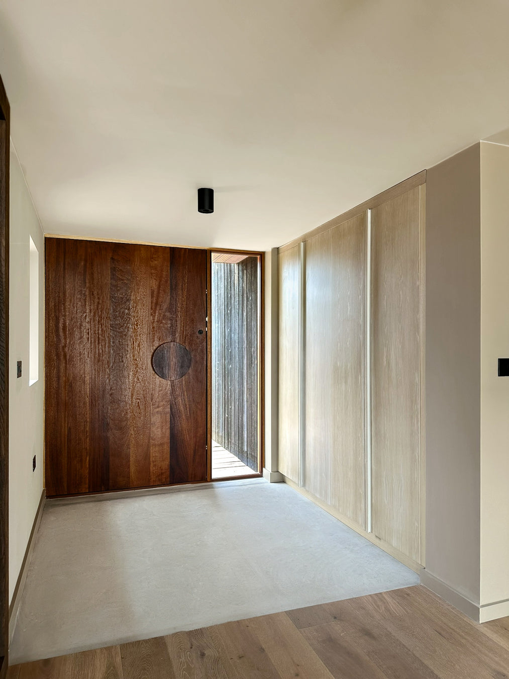 Modern interior with wooden door and oak white washed storage
