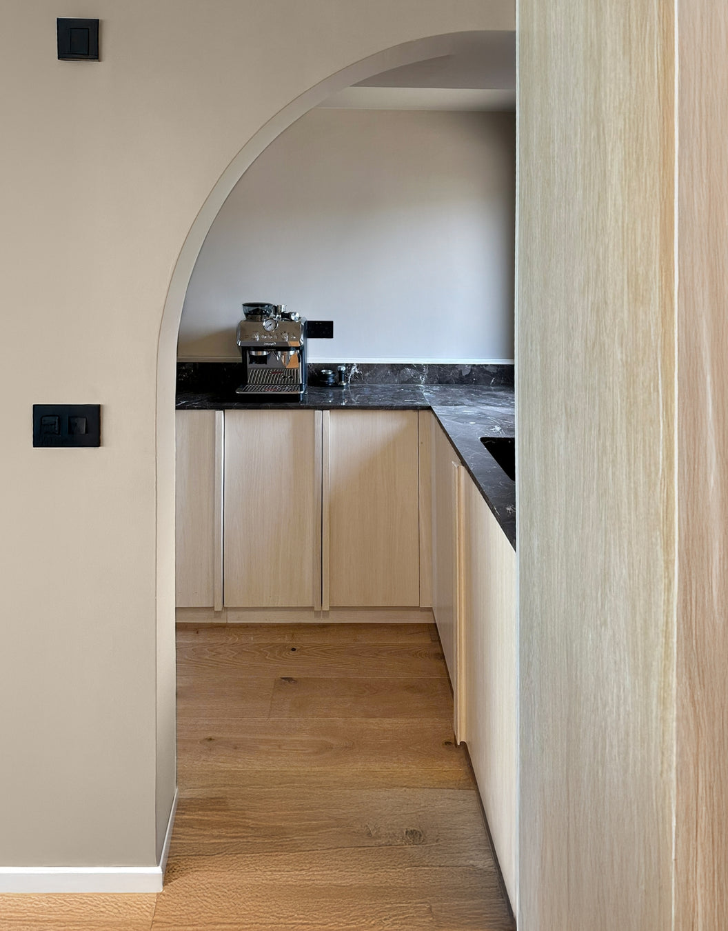 Oak kitchen with wooden floor and light-coloured cabinets