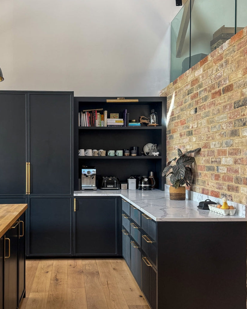 Modern kitchen withshaker kitchen cabinets, open shelf, and brick wall.