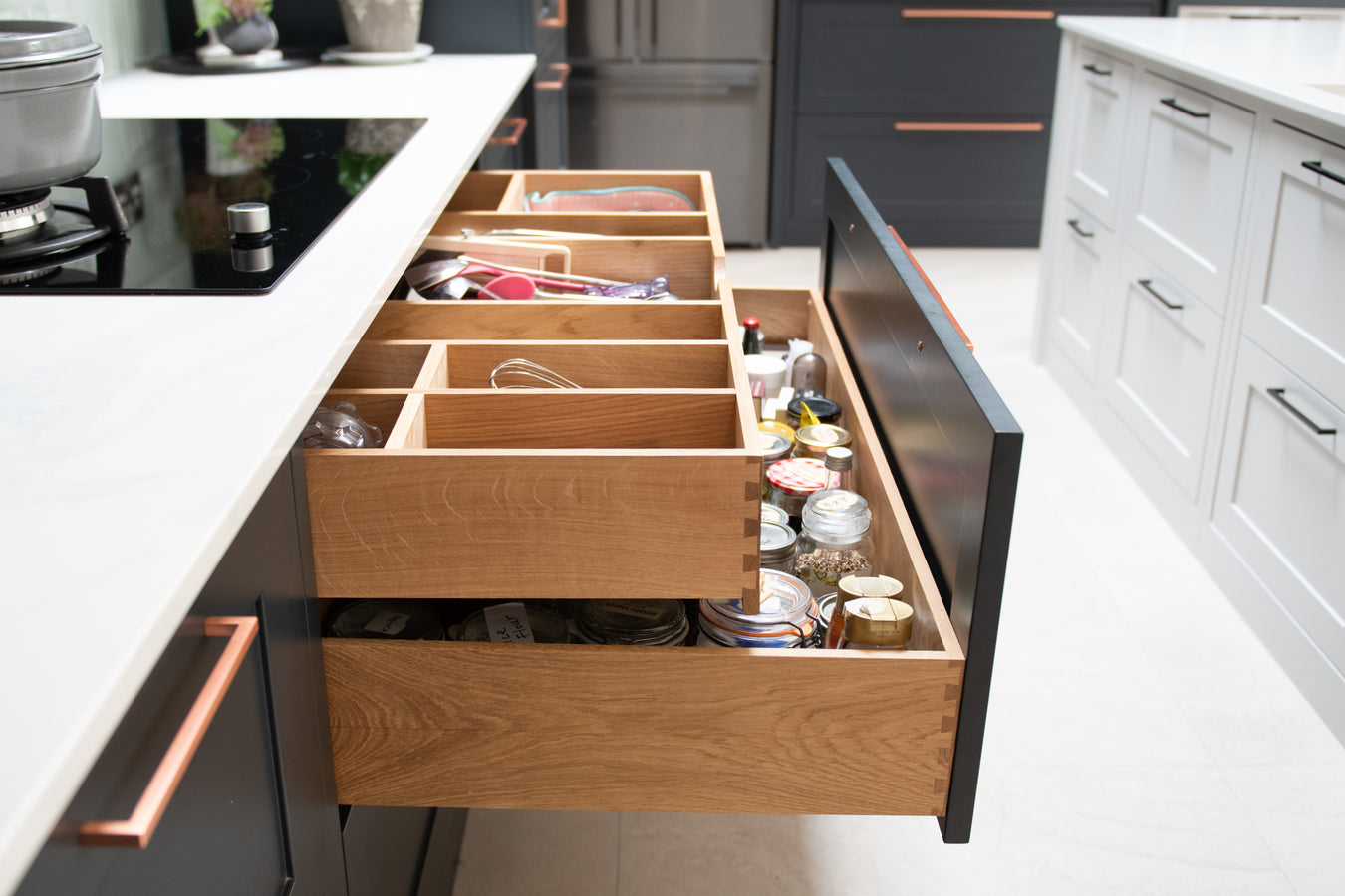 Open kitchen drawer with various items in a modern kitchen setting