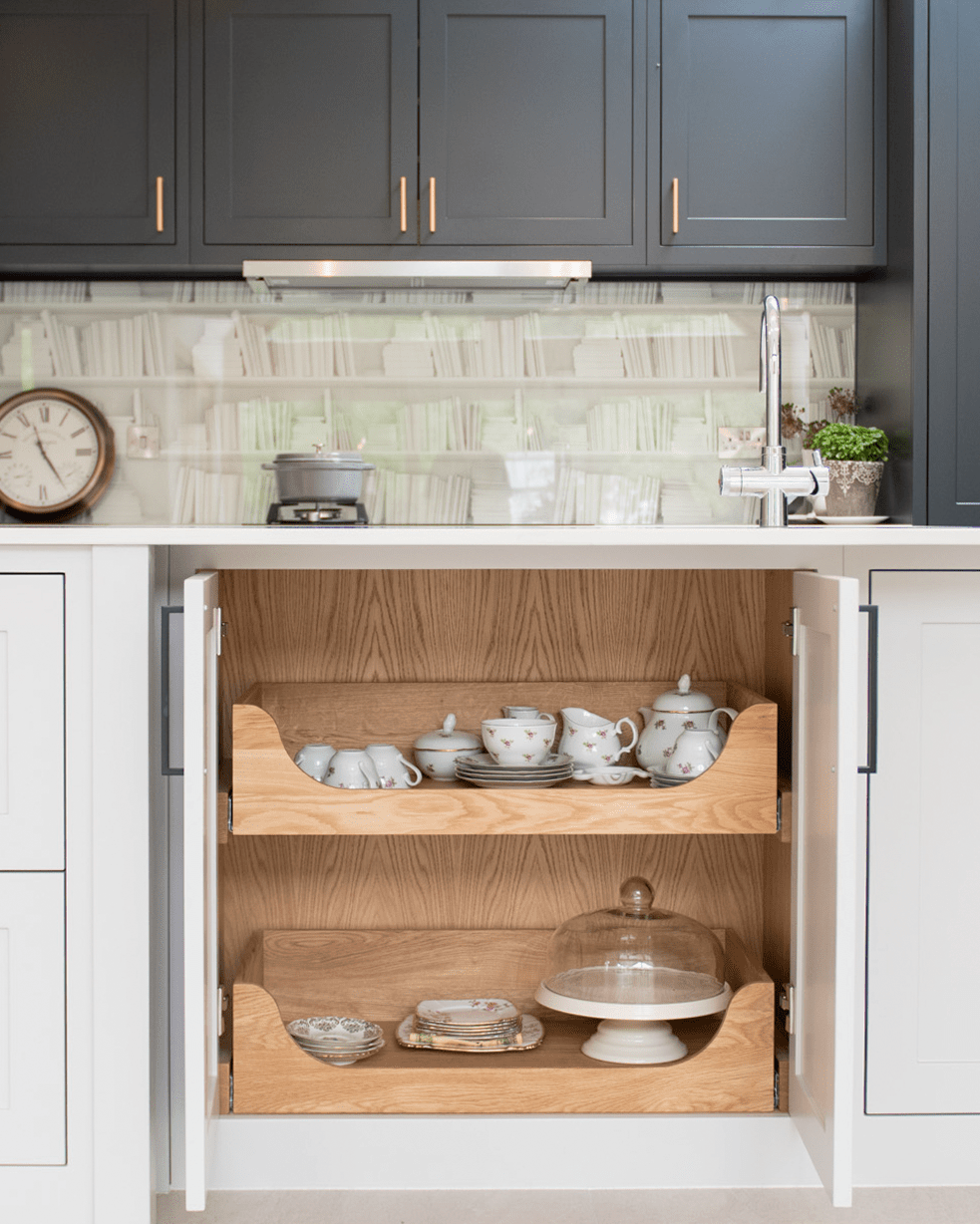 Kitchen with open cabinet revealing wooden shelves with kitchenware.