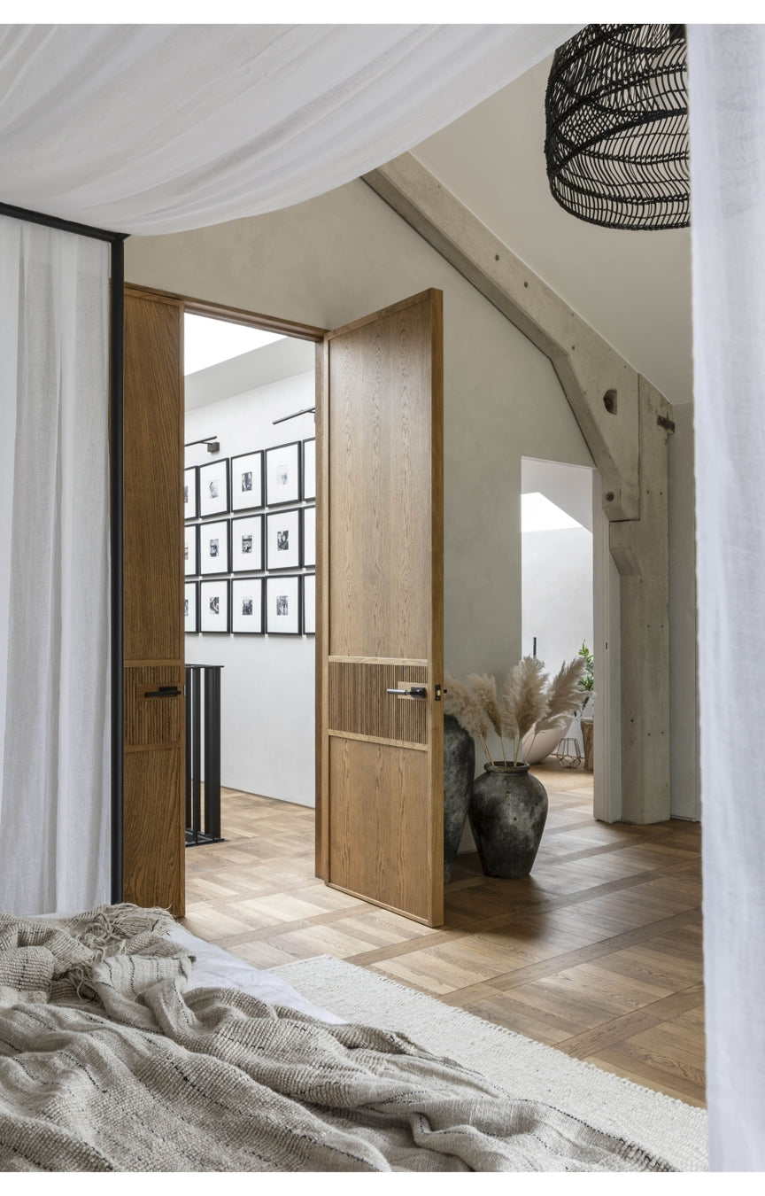 Open oak internal door leading to a room with decor elements.