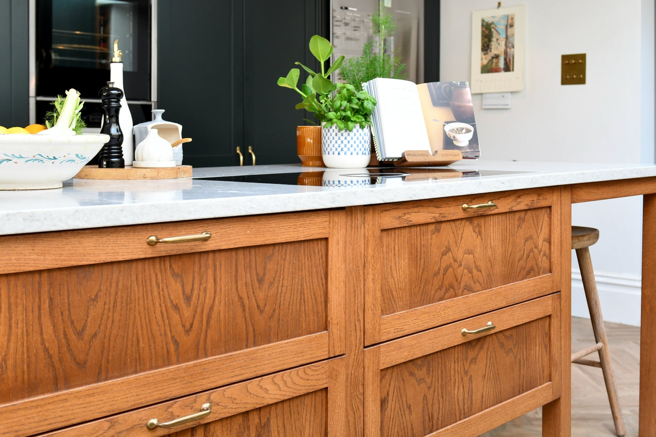 Oak kitchen island with quartz worktop,kitchen utensils, and decor.