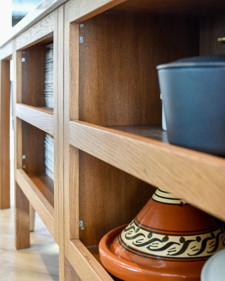 Open oak shelf with ceramic pots on a light wood floor