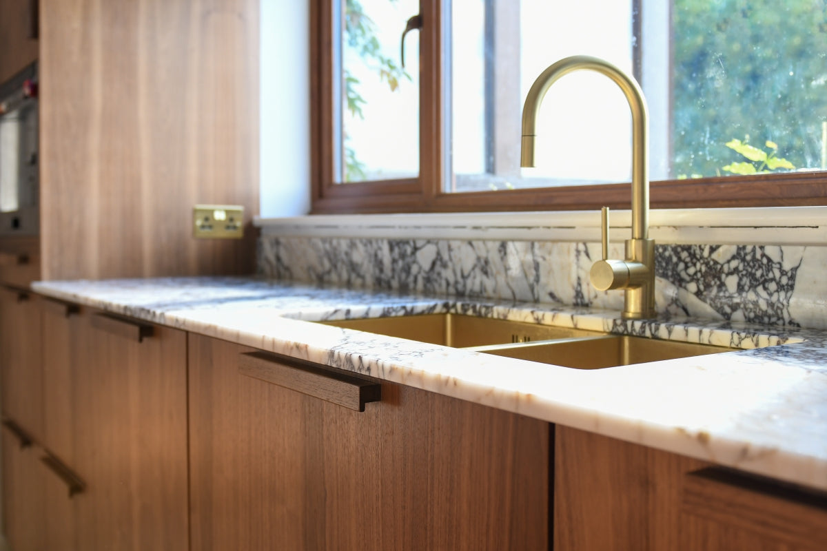 Walnut kitchen with a brass tap and quartz top on IKEA METOD