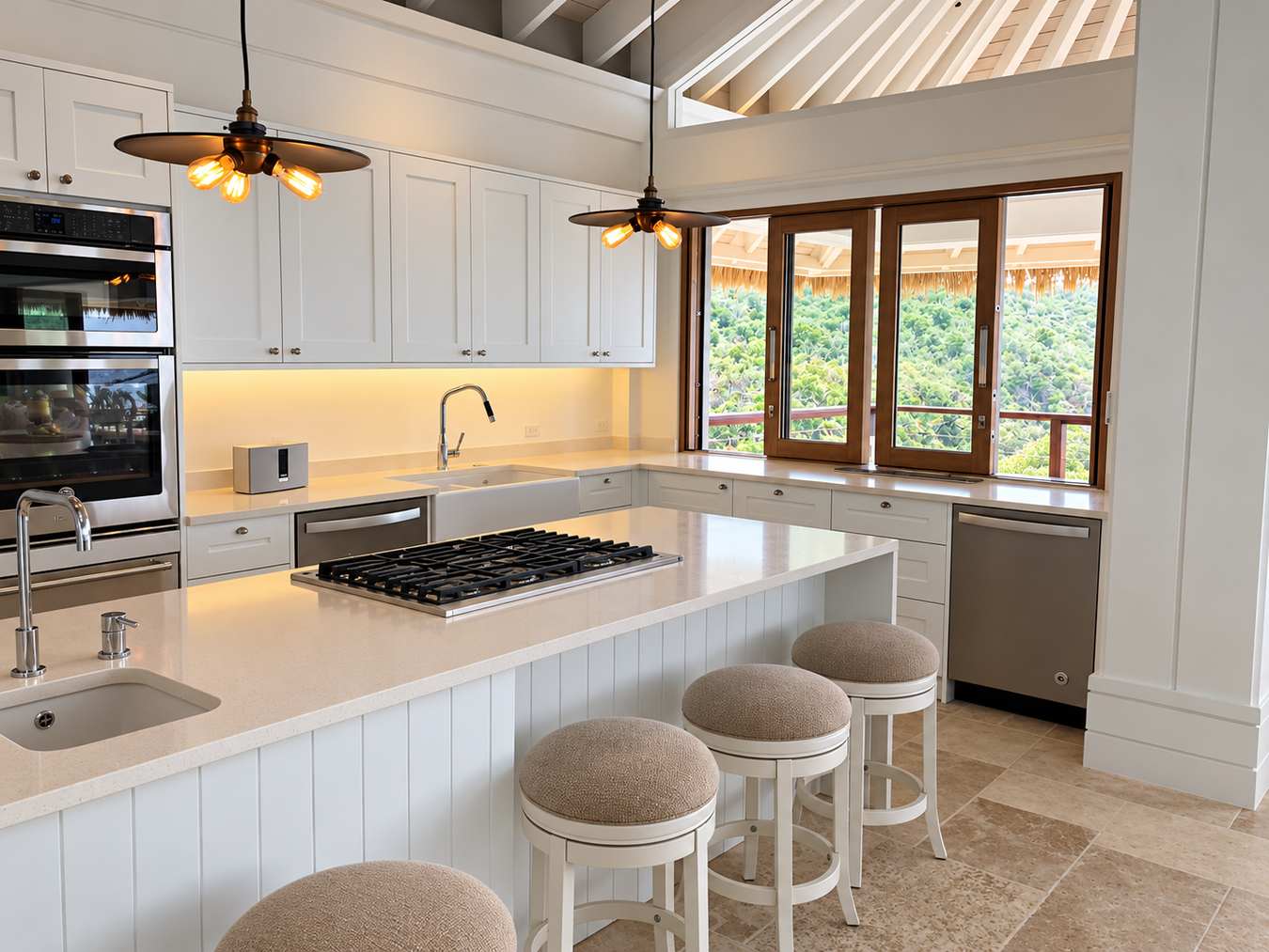 A bright, modern shaker kitchen island with white cabinetry, a black gas cooktop, beige upholstered bar stools, and large windows overlooking a lush green outdoor area.